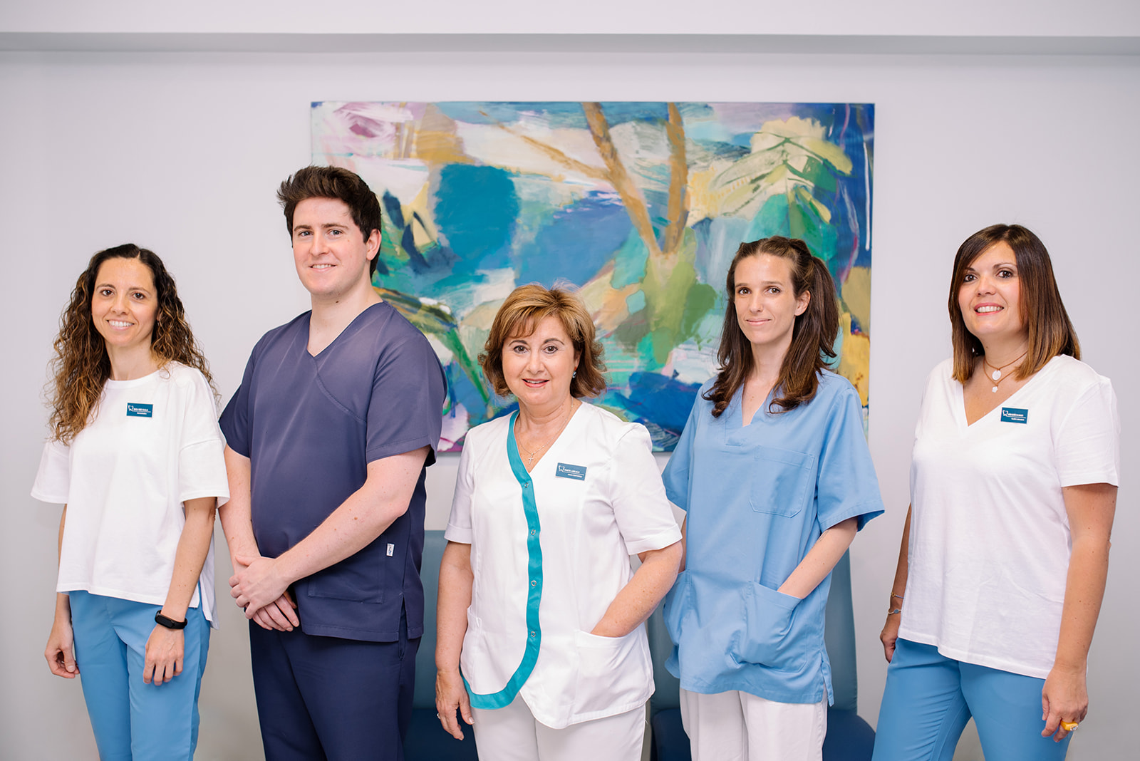 Equipo de clínica dental Urraca posando en la consulta con cinco profesionales uniformados.