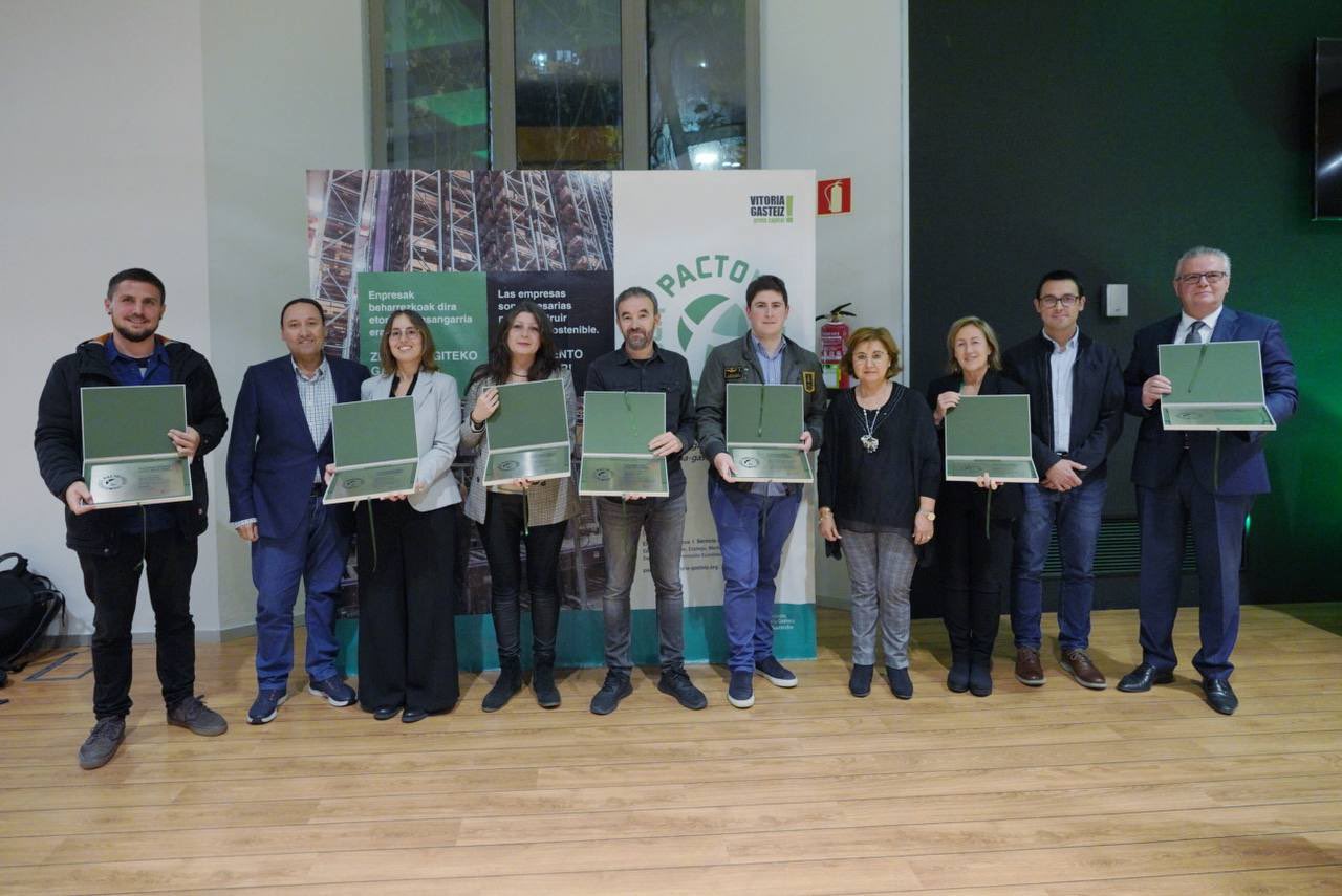 Grupo de personas posando con placas de premio en un acto de buenas prácticas medioambientales.